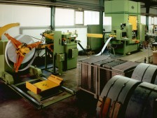 Stanzautomat bestehend aus einem Coilladewagen, Abwickelhaspel, Richtmaschine mit Einführhilfe, Walzenvorschubgerät, hydraulischer Presse und Stanzstreifenzerhacker.