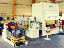 Feinstanzautomat, konfiguriert mit  Abwickelhaspel mit Coilladewagen, Einfädelvorrichtung, Vorschubrichtmaschine und hydraulische Presse HPV / F 450 (Integrales Feinschneiden)
